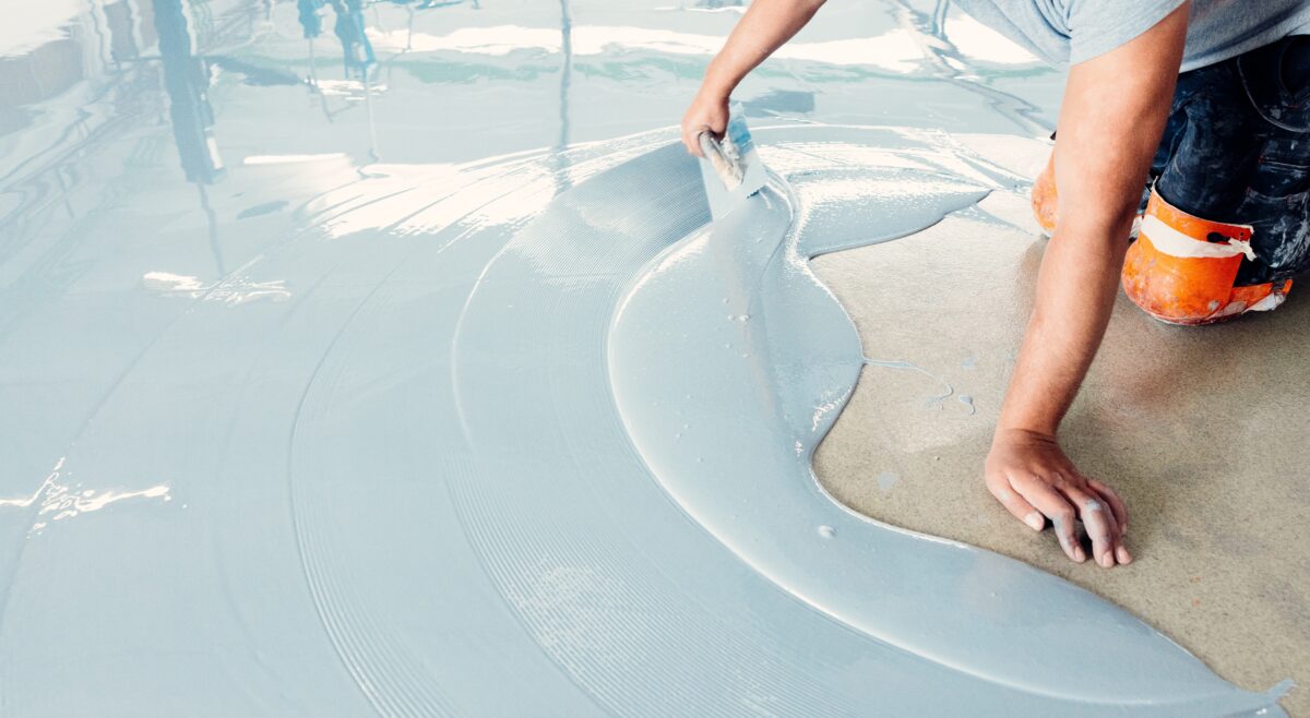 Technician spreading epoxy on a cement surface