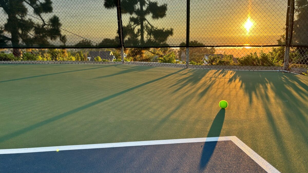 Sunset over tennis court with tennis ball