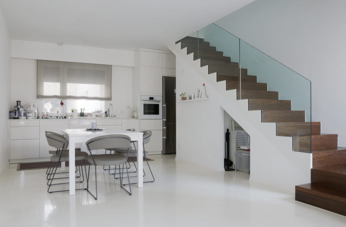 White, modern kitchen and stairway with epoxy flooring